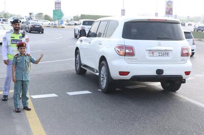 Abdullah Al Katbi gets some advice from an officer as he directs traffic in Ras Al Khaimah on Sunday morning. RAK Police