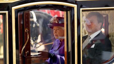Britain's Queen Elizabeth and King Willem-Alexander of the Netherlands leave in a horse-drawn carriage after a ceremonial welcome during a state visit. Matt Dunham / AFP