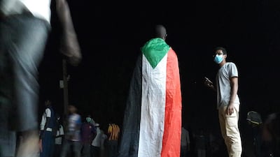 A Sudanese demonstrator wears a national flag during an anti-government protest in the Haj Yousef neighbourhood of the Bahari district in the capital Khartoum. AFP