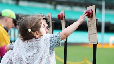 Cricket fans inspect memorabilia showing Shane Warne's Sydney Cricket Ground Test wickets during the simulcast of the state memorial service for Shane Warne at the Sydney Cricket Ground. Getty