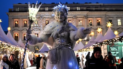 A woman dressed as a snow queen performs at the Christmas market at Babelplatz in Berlin. EPA