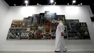 A visitor walks past the work of Thai artist Navin Rawanchaikul during Art Dubai, the leading contemporary art fair for the Middle East and south Asia on March 18, 2014 in Dubai, United Arab Emirates. The 2014 edition takes place from March 19-22 at Madinat Jumeirah and includes 80+ galleries, the Global Art Forum, commissioned projects and more. Photo by Francois Nel/Getty Images for Art Dubai