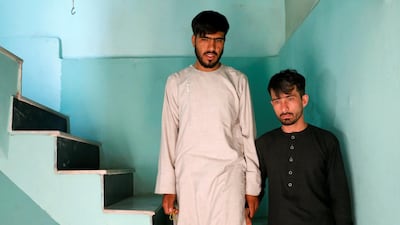 Mirwais Elmi 26, (R) with a relative at his home. Reuters