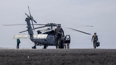 US sailors conducting maintenance on a military helicopter, on the flight deck of aircraft carrier USS Abraham Lincoln. AFP