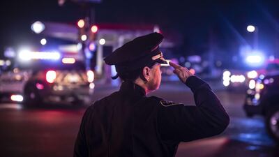A police officer salutes as a procession carrying the body of a fellow officer leaves King Sooper's grocery store. Getty Images