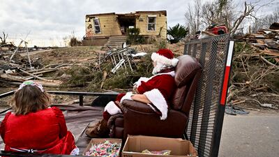 Steely Vanlue, dressed as Mrs. Claus, and Troy Black, dressed as Santa Claus, pass by a destroyed home in Dawson Srpings, Kentucky, on Christmas Eve after tornadoes ripped through several US states. Reuters