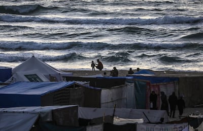 Palestinians stand on the beach near makeshift shelters at a new camp for internally displaced people west of Khan Younis in southern Gaza. EPA