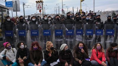 Women sit on the ground and shout slogans during the protest. EPA