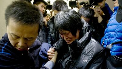 A Chinese relative of passengers aboard a missing Malaysia Airlines plane cries as she leaves a hotel room for relatives or friends of passengers aboard the missing plane. Andy Wong / AP Photo