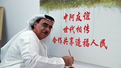Emirati Artist, Mohammed Mandi works on his collaborative painting with Chinese artist and teacher, Jack Lee. Victor Besa / The National