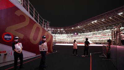 Members of staff hold signage inside the stadium before the opening ceremony.
