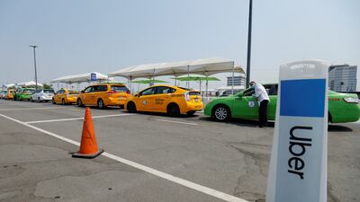Taxis line up next to an Uber pick-up area along with Uber and Lyft drivers. Reuters
