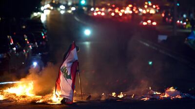 A Lebanese national flag is held on the Ring bridge in Beirut. EPA