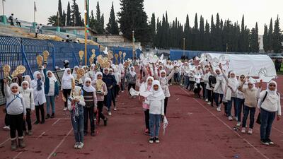Girls line up and pose together at the newly reopened Idlib Municipal Stadium