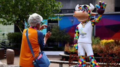 A volunteer takes a photo of the Perry the Bull, the official mascot of the Commonwealth Games, at the NEC. Getty Images