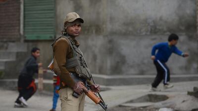 An Indian paramilitary trooper stands guard in downtown Srinagar as government forces enforce restrictions during a separatist strike demanding the Indian Army cease using a Kashmir meadow as its test firing range for heavy artillery. Tauseef Mustafa / AFP