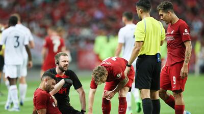 Liverpool's Alex Oxlade-Chamberlain receives treatment for an injury during the Singapore Trophy 2022 soccer match between Liverpool and Crystal Palace, in Singapore, Friday, July 15, 2022. (AP Photo / Danial Hakim)