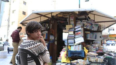 Mohammed Al Maaytah, the nephew of Hisham, stands near his uncle's bookstore, which recently re-opened after being burnt down last month. Salah Malkawi for The National
