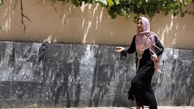 An afghan woman surveys the damage caused by the bomb, keeping her distance. EPA