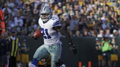Dallas Cowboys' Ezekiel Elliott runs past a defender in an NFL game in October. Morry Gash / AP Photo