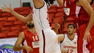 A player from Jordan's Al Riyadi Aramex of Amman, white, attempts a layup against Egypt, red. Satish Kumar / The National