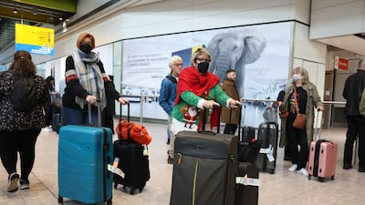 Airline passengers wear face masks in the arrivals hall at Heathrow Airport in London, on December 23. Bloomberg.