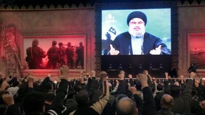 Supporters salute as the Hizbollah leader, Hassan Nasrallah, makes a televised address.