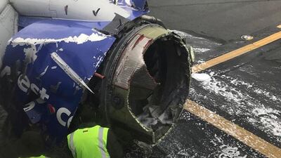 The engine of a Southwest Airlines plane is inspected as it sits on the runway at the Philadelphia International Airport after it made an emergency landing. AP
