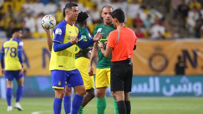 Cristiano Ronaldo talks to Saudi referee Majed Al-Shamrani during the Saudi Pro League football match between Al Nassr and Al Khaleej.