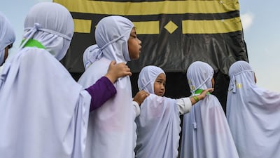 Malaysian Muslim girls from the Little Caliphs kindergarten circumambulate a mockup of the Kaaba.