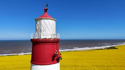 Specialists abseil down Happisburgh Lighthouse in Norfolk to carry out a structural survey inspecting cracks and damage to the landmark. PA