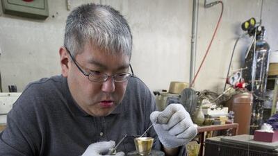 A craftsman works on a brass metal product at the Nousaka metal crafts factory in Takaoka. Everett Kennedy Brown / EPA