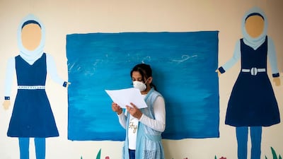 A Palestinian school girl views her end of year certificate upon receiving it at a school in Gaza City. AFP