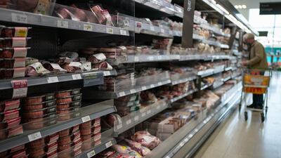 Shopper in the fresh meat aisle in a supermarket. PA