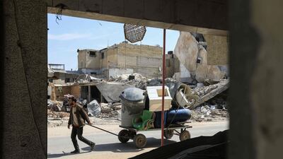 A Syrian man pulls a wagon filled with belongings as he flees the shelling. Abdullah Hammam / AFP Photo