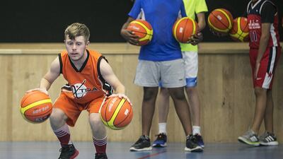 Vincent Baur-Richter, a 20-year-old with Down syndrome, plays with his basketball team. His father was surprised to find sports clubs in Abu Dhabi were happy to have Vincent on their team. Mona Al Marzooqi / The National