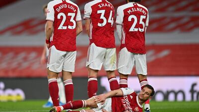 Arsenal's Cedric Soares lies down behind a wall before a Tottenham Hotspur free kick. Reuters