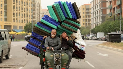 A man carries blankets for displaced residents on a motorcycle in Beirut. EPA