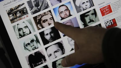 A picture taken on February 2, 2012, in Beirut shows a man pointing to pictures of people allegedly killed during the massacre. AFP