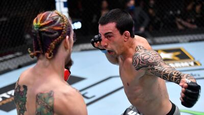 Thomas Almeida of Brazil punches Sean O'Malley in their bantamweight fight during the UFC 260 event at UFC APEX in Las Vegas, Nevada. Jeff Bottari / USA TODAY Sports / Reuters