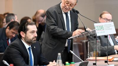 French Foreign Minister Jean-Yves Le Drian looks at Lebanese Prime Minister Saad Hariri as he delivers his opening speech at the conference for international donors and investors to support Lebanon's economy, held in Paris on April 6, 2018. Eric Feferberg / Pool via Reuters