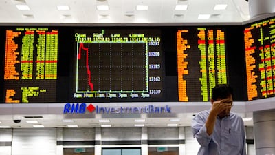 An investor walks in front of trading boards at a private stock market gallery in Kuala Lumpur, Malaysia. The economics chief at the Bank for International Settlements warns the economy is shaky. AP