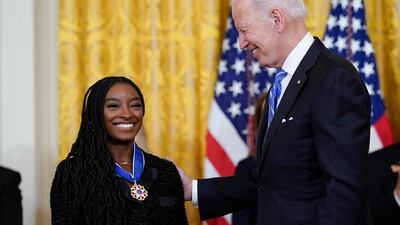 Mr Biden awards Simone Biles, the most decorated US gymnast in history. AP