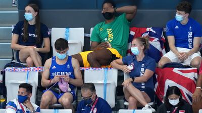 Great Britain's Tom Daley knits in the stands during the final of the women's 3-metre springboard at the Tokyo Aquatics Centre. PA Wire