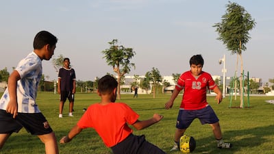 Children play football at the Umm Al Seneem Park, which has the world's longest air-conditioned outdoor path, in Doha. AFP