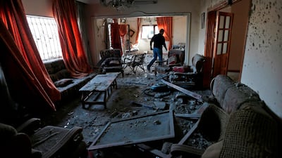 A Palestinians man walks among debris and scatterred objects. AFP