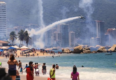 Tourists watch an airplane show in Acapulco, Guerrero. EPA