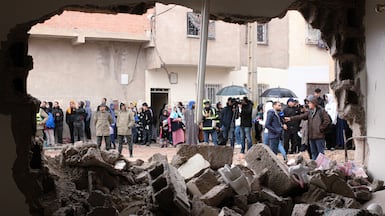 Residents and jounalists watch as rescue workers search for survivors, amid the wreckage of two collapsed buildings in Fez, Morocco. AP