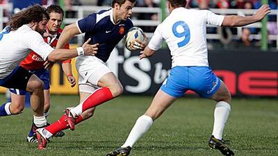 France's Vincent Clerc, centre, is tackled by Italy's Martin Castrogiovanni, left, and Fabio Semenzato during the Six Nations in Rome yesterday. It was Italy's first win over France in the competition.