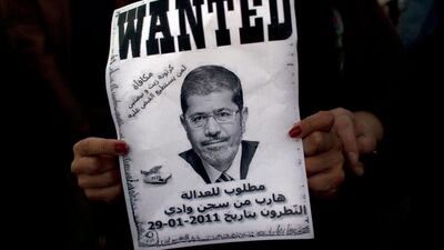 An Egyptian in Cairo protester carries a poster with a picture of president Mohammed Morsi and Arabic script that reads: Wanted for justice, escaped from the Natroun valley prison in January 29, 2011, Reward, a box of oil and two eggs. Nasser Nasser / AP Photo